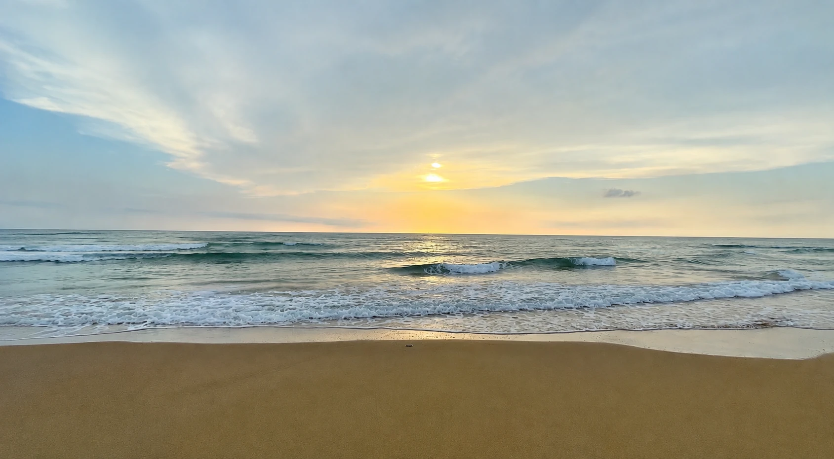 Mare al tramonto visto dalla spiaggia, orizzonte aperto