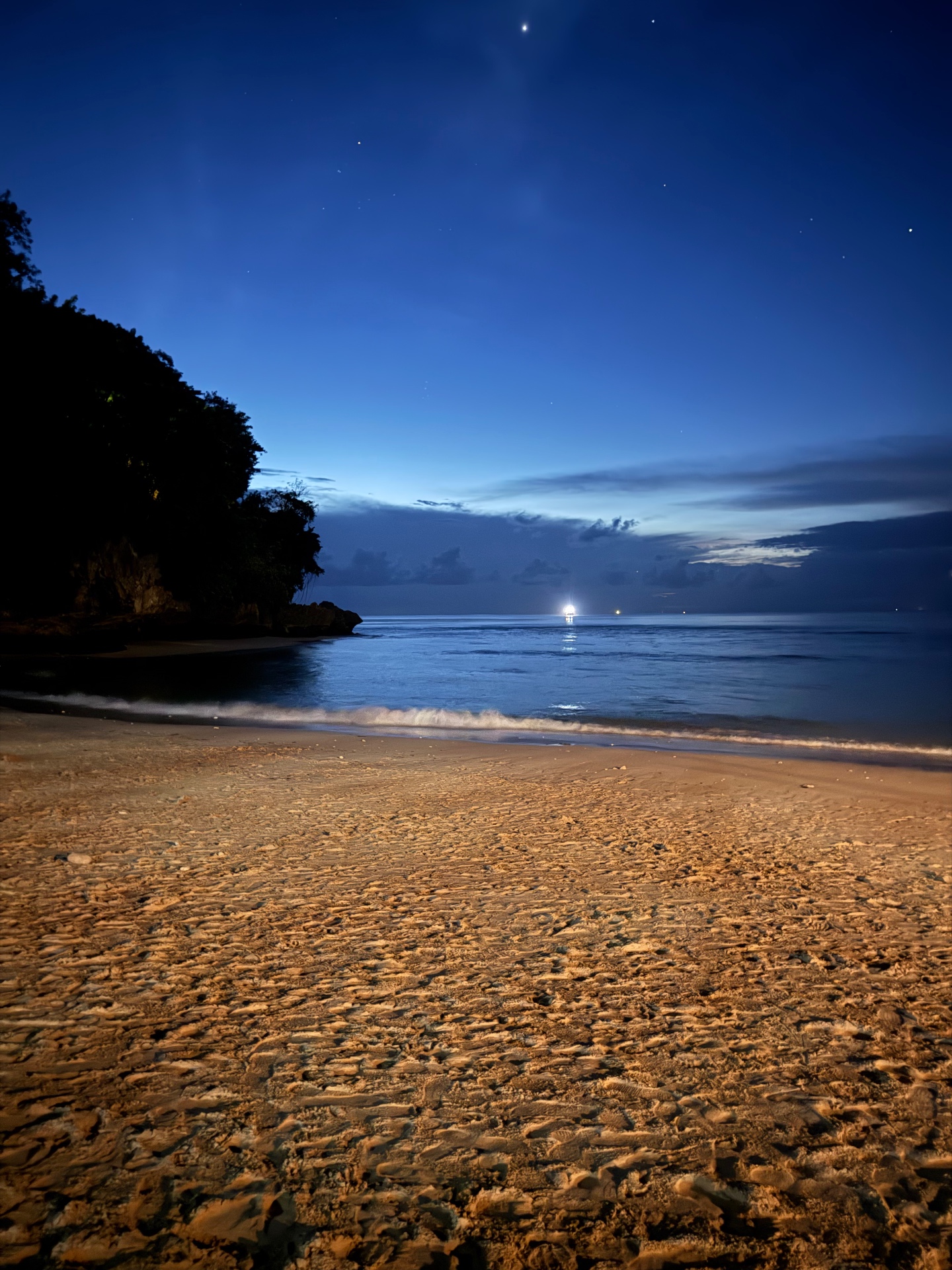 Spiaggia di Padang Padang a Bali all'imbrunire con cielo blu e stelle