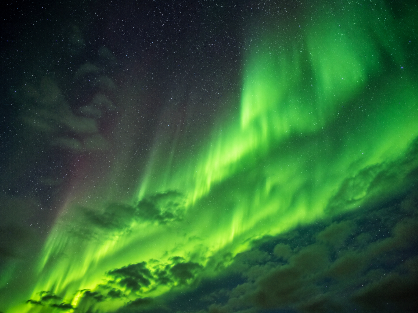 Aurora boreale in Islanda con cielo verde sopra le nuvole