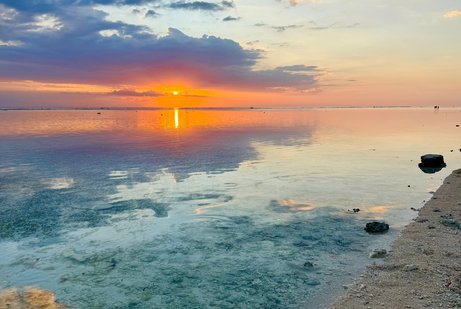 Tramonto balinese su laguna trasparente con riflessi rosa e turchese