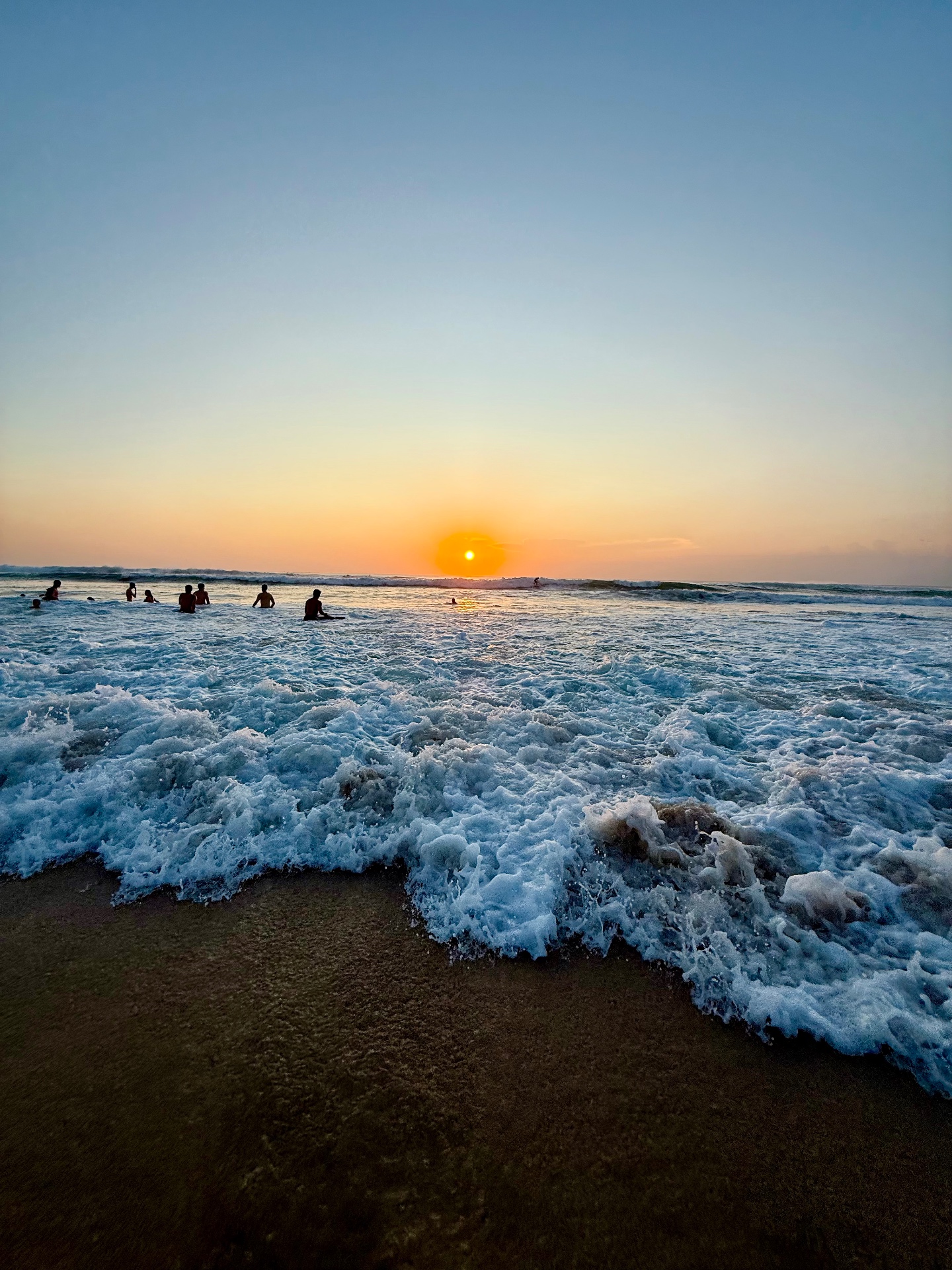 Tramonto sulla spiaggia con riflessi caldi sull'acqua